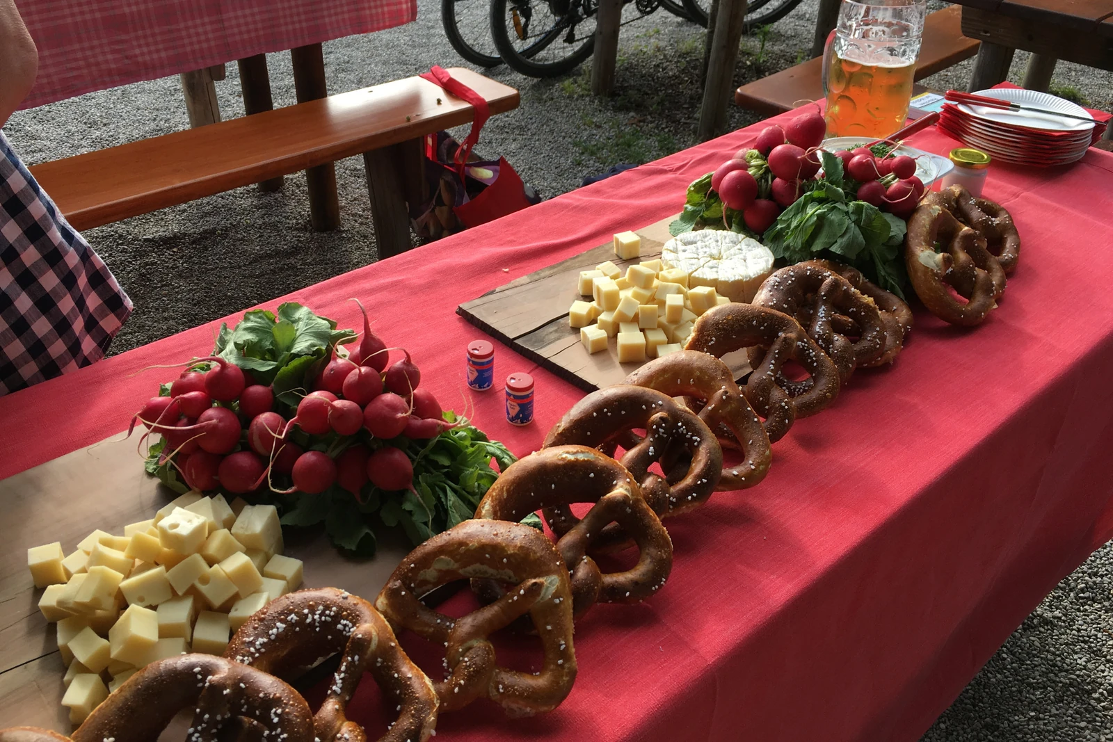 Brotzeit mit Brezn, Käse und Radieschen in einem Münchner Biergarten